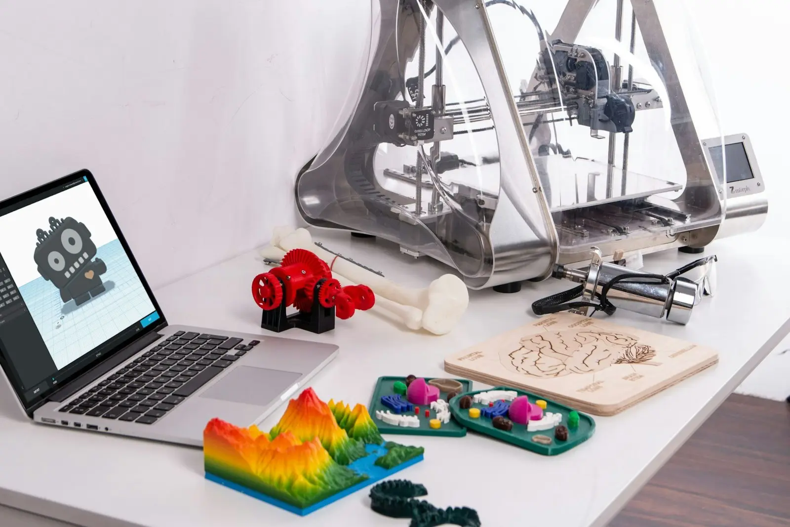 3D-Drucker mit Laptop und gedruckten Werkstücken
